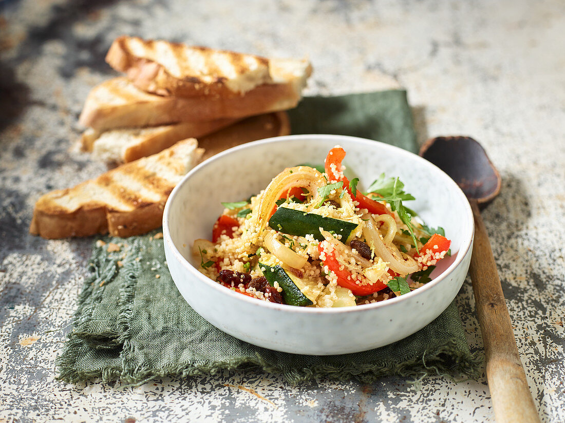 Couscous with oven-baked Moroccan vegetables served with toasted baguette