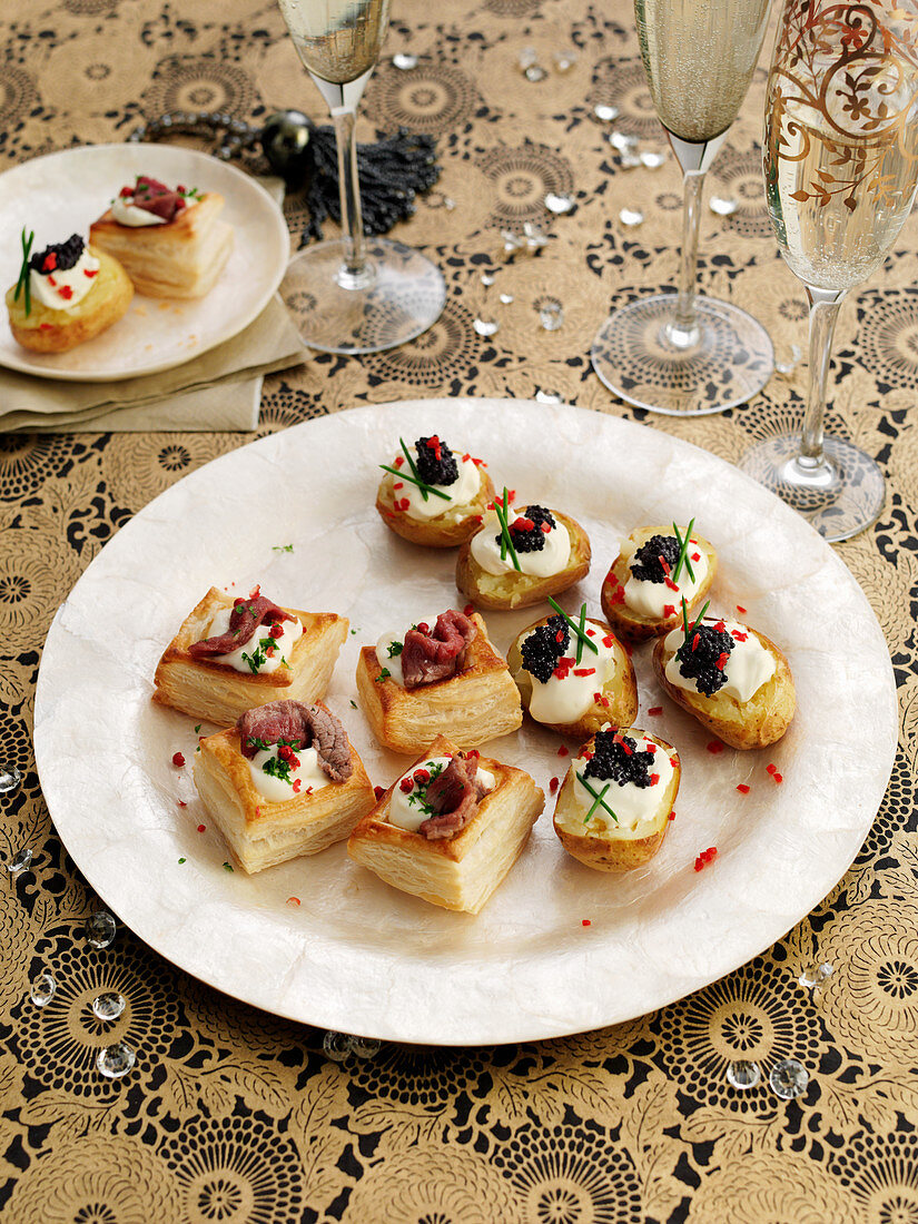 Various snacks (puff pastry with roast beef, potatoes with sour cream and caviar)