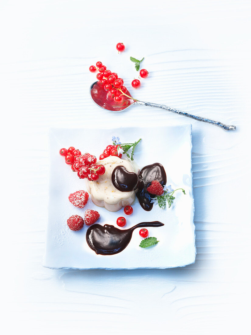 Pudding with chocolate sauce and berries