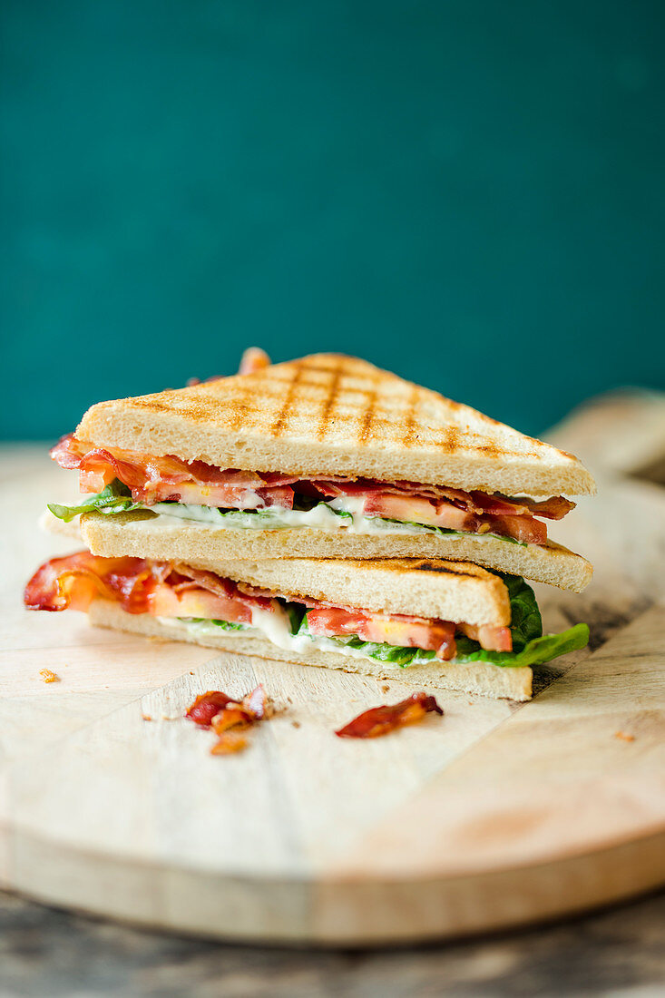 BLT sandwiches on a wooden plate