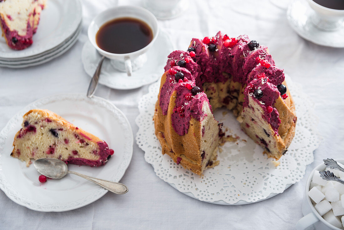 Vegan redcurrant Bundt cake on a table laid for a coffee morning