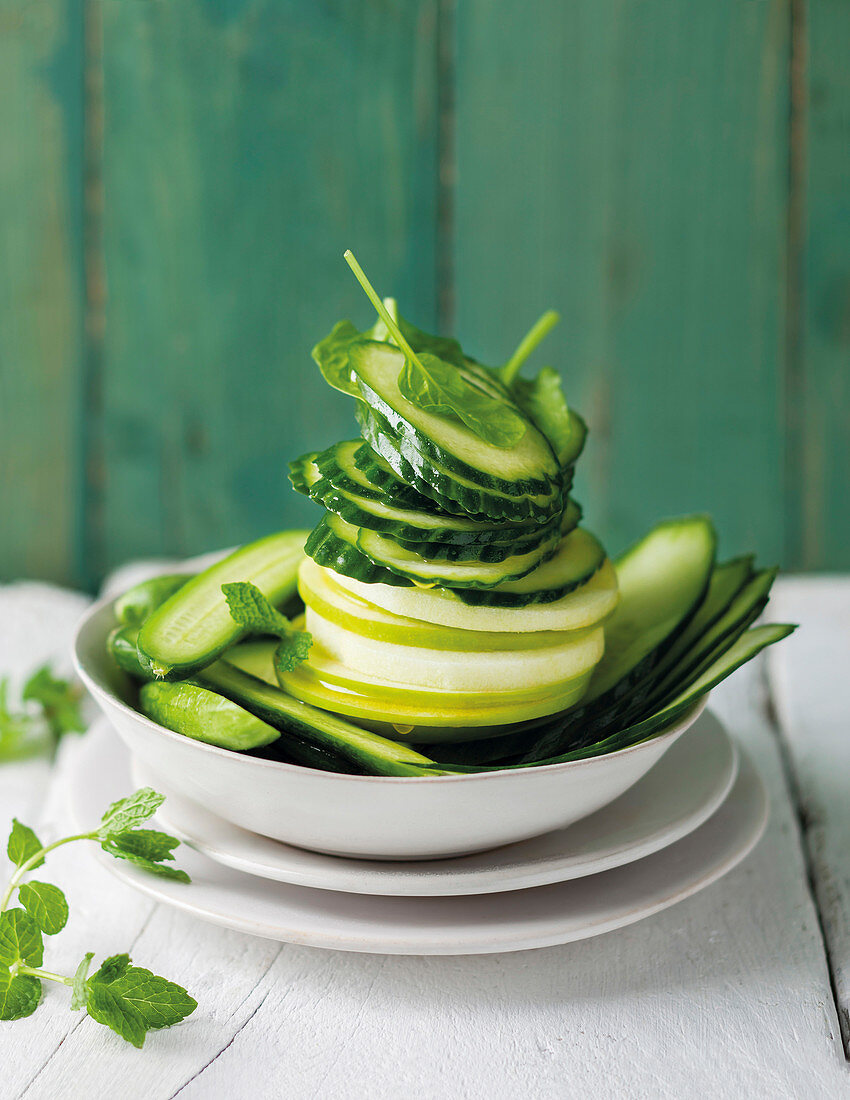 Fresh cucumber and apple slices in a bowl