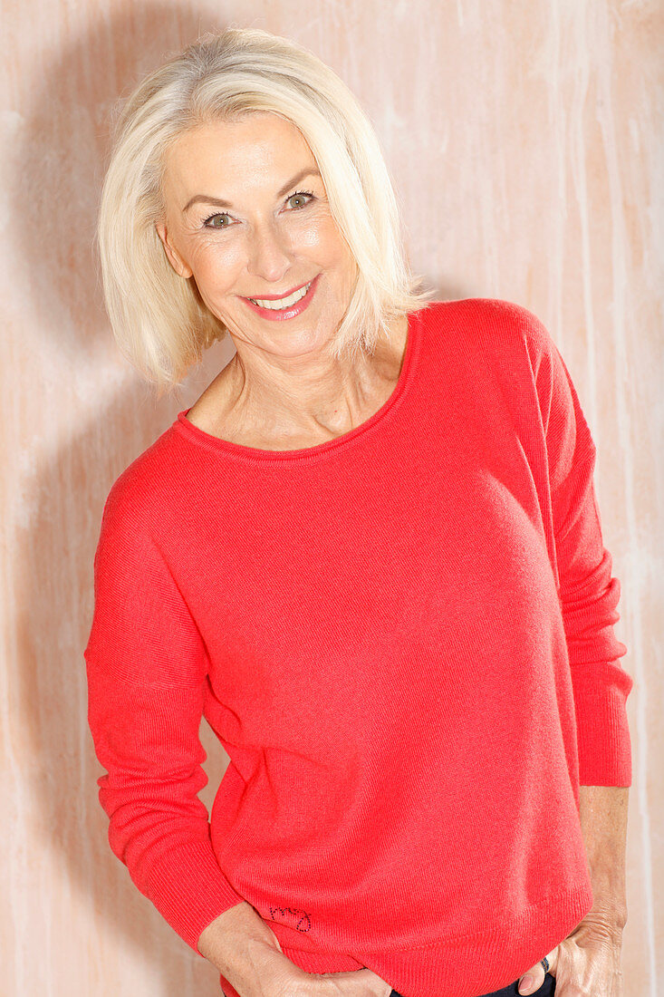 Ältere blonde Frau in rotem Pullover