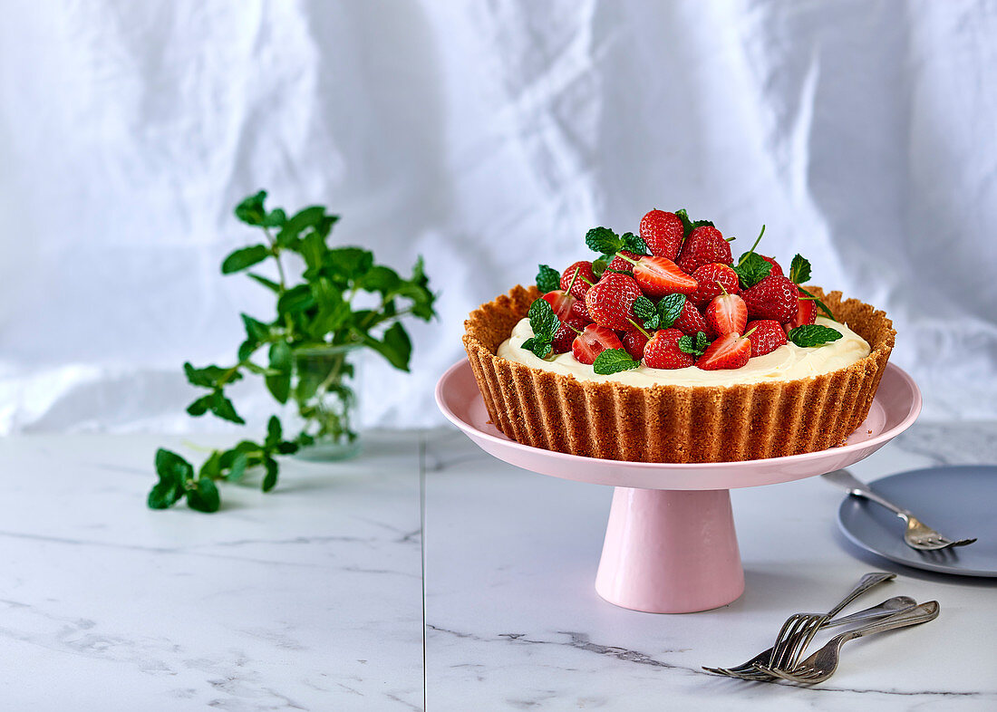 No-bake cheesecake flavoured with rose and lemon and topped with fresh strawberries