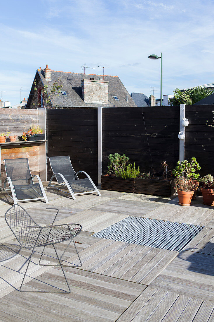 Sonnenliegen und Designerstuhl auf Dachterrasse