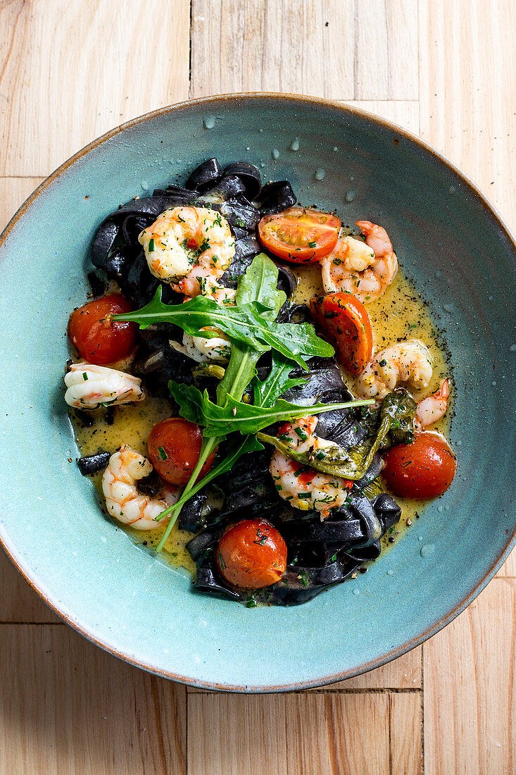 Black tagliatelle with prawns, tomatoes and rocket