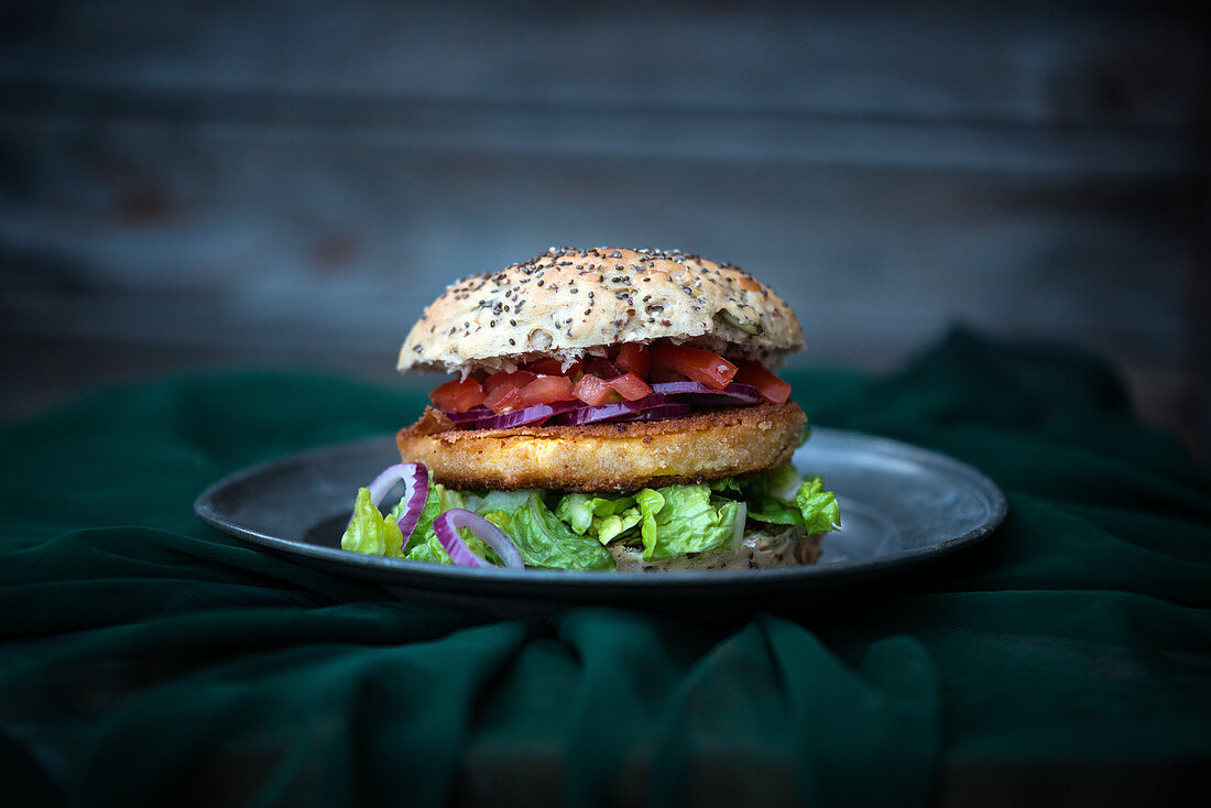 Veganes Chia-Brötchen mit Steckrübenschnitzel, Tomaten, roten Zwiebeln und Salat