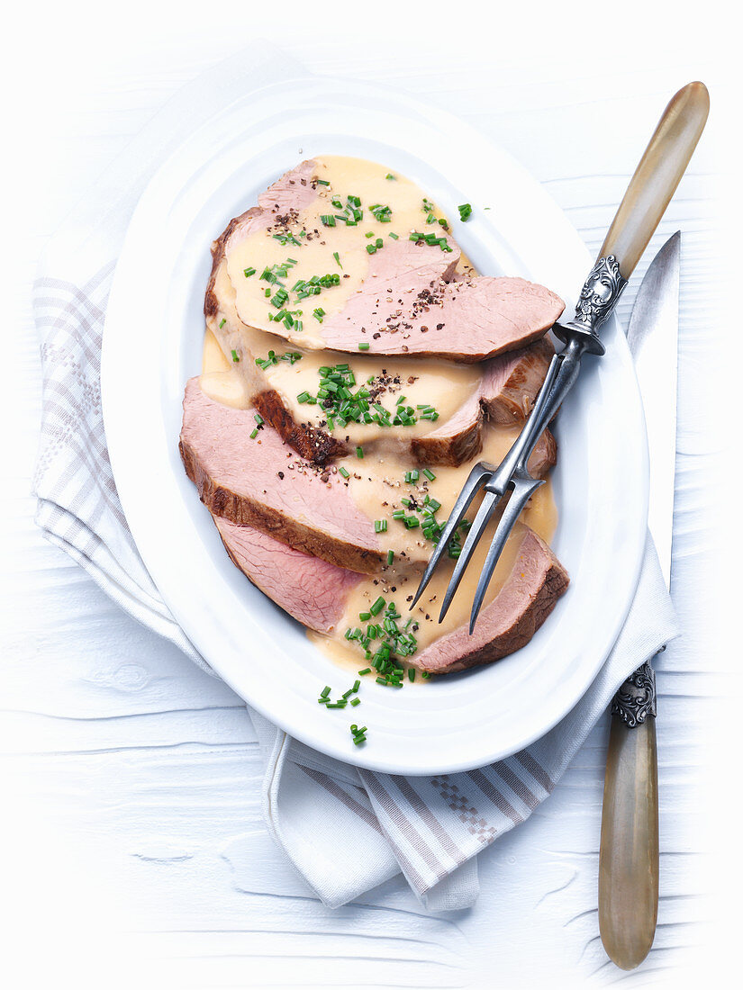 Roast veal with a creamy sauce garnished with chives