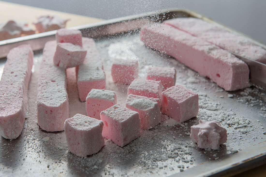 Marshmallows being dusted with icing sugar