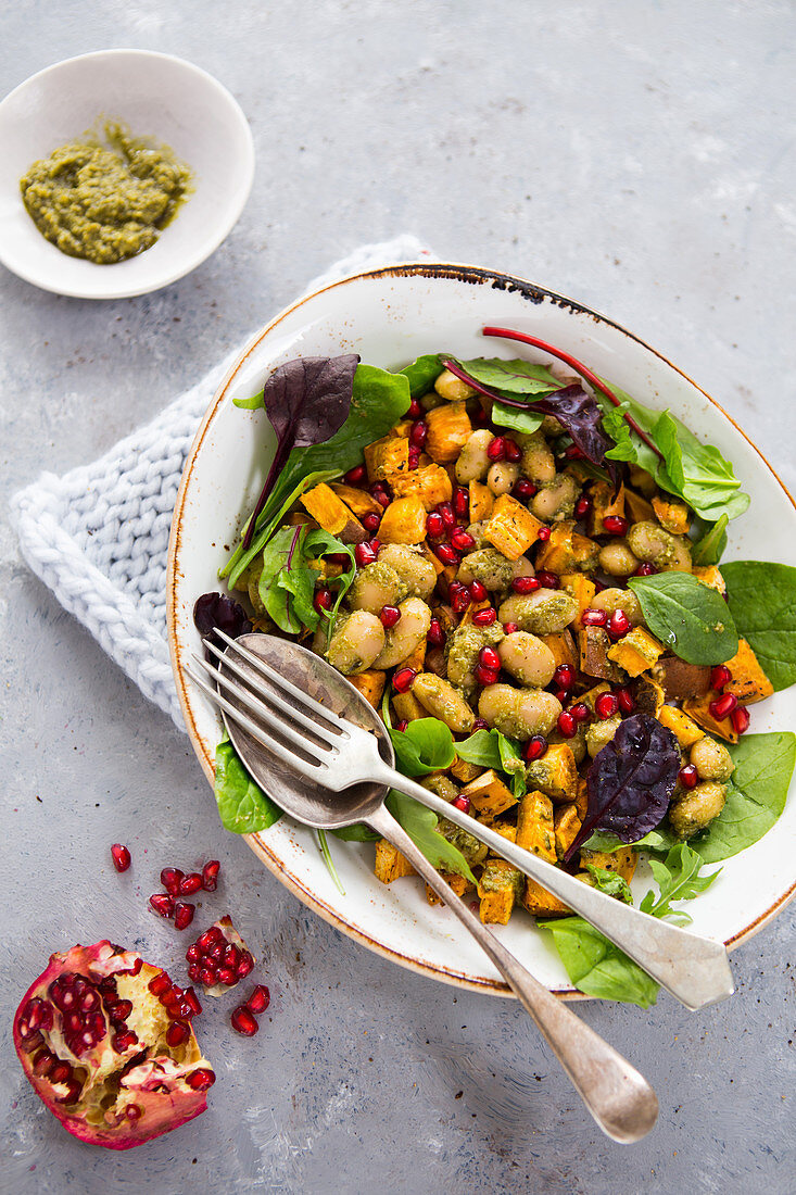 Vegetable salad with butter beans, sweet potatoes, pomegranate seeds and pesto