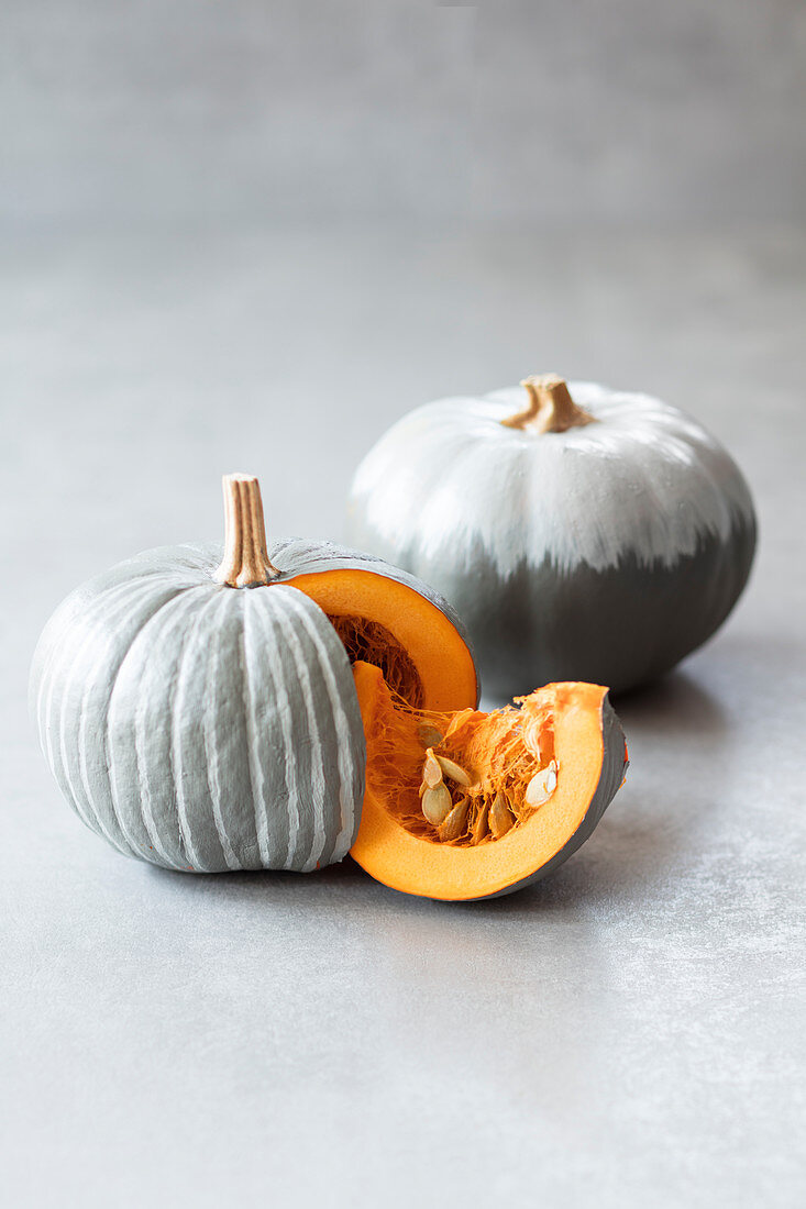 Pumpkins painted grey with white stripes and grey ombré