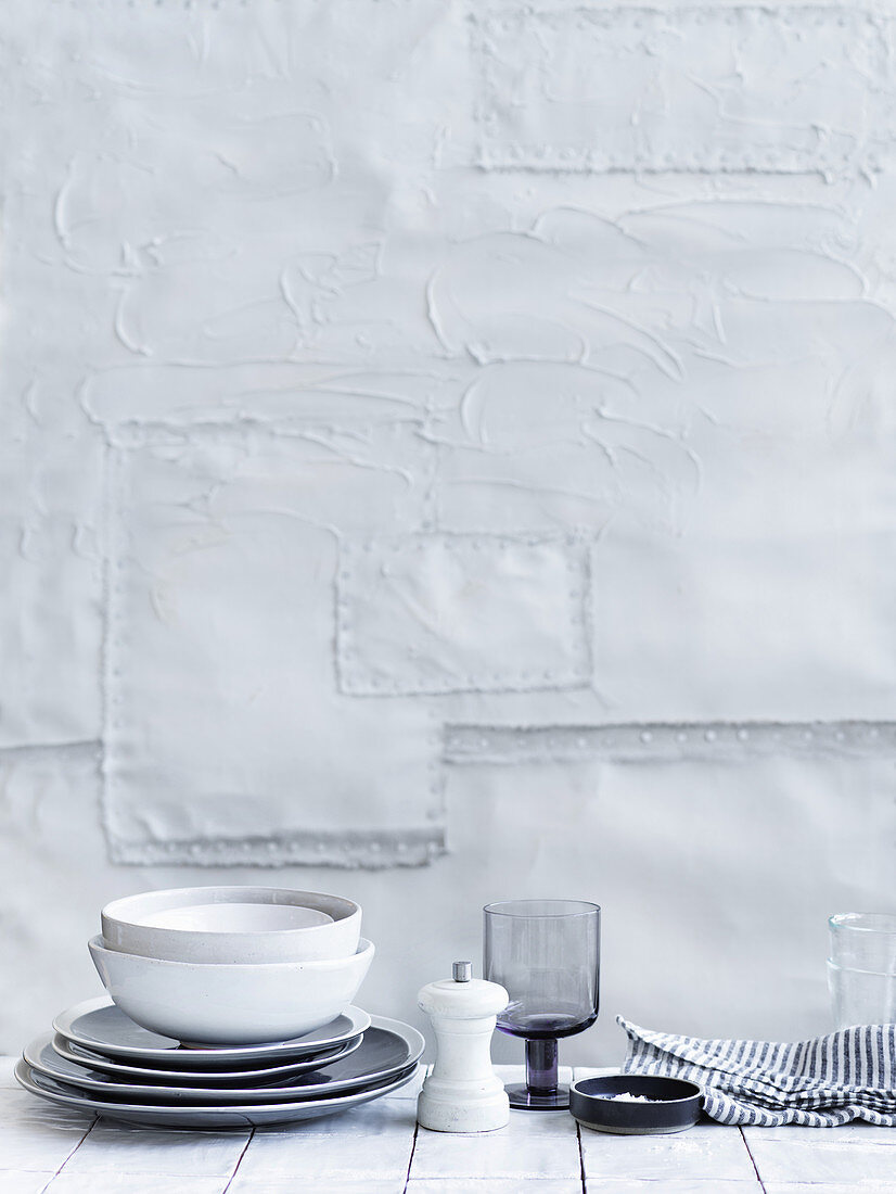 White and grey dishes in front of a white wall