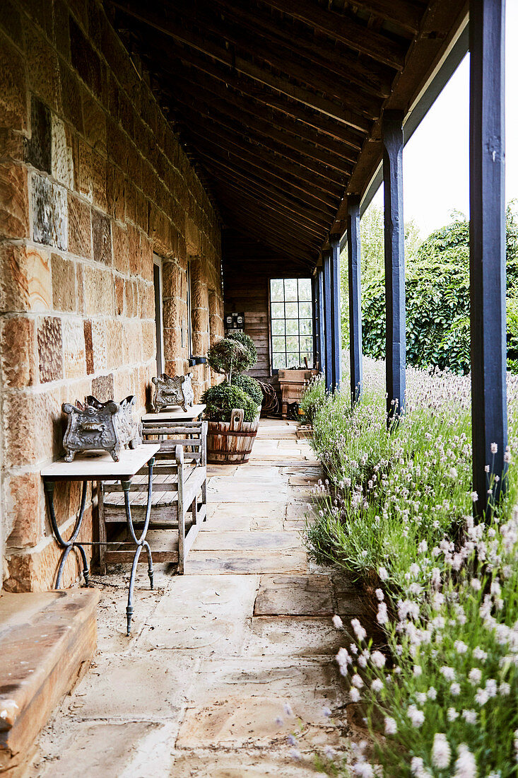 Veranda eines Natursteinhauses mit Lavendelbeeten