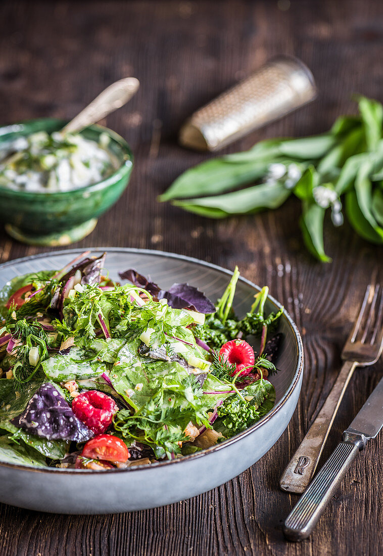 Wild herb and asparagus salad with tomatoes, raspberries and wild garlic cream