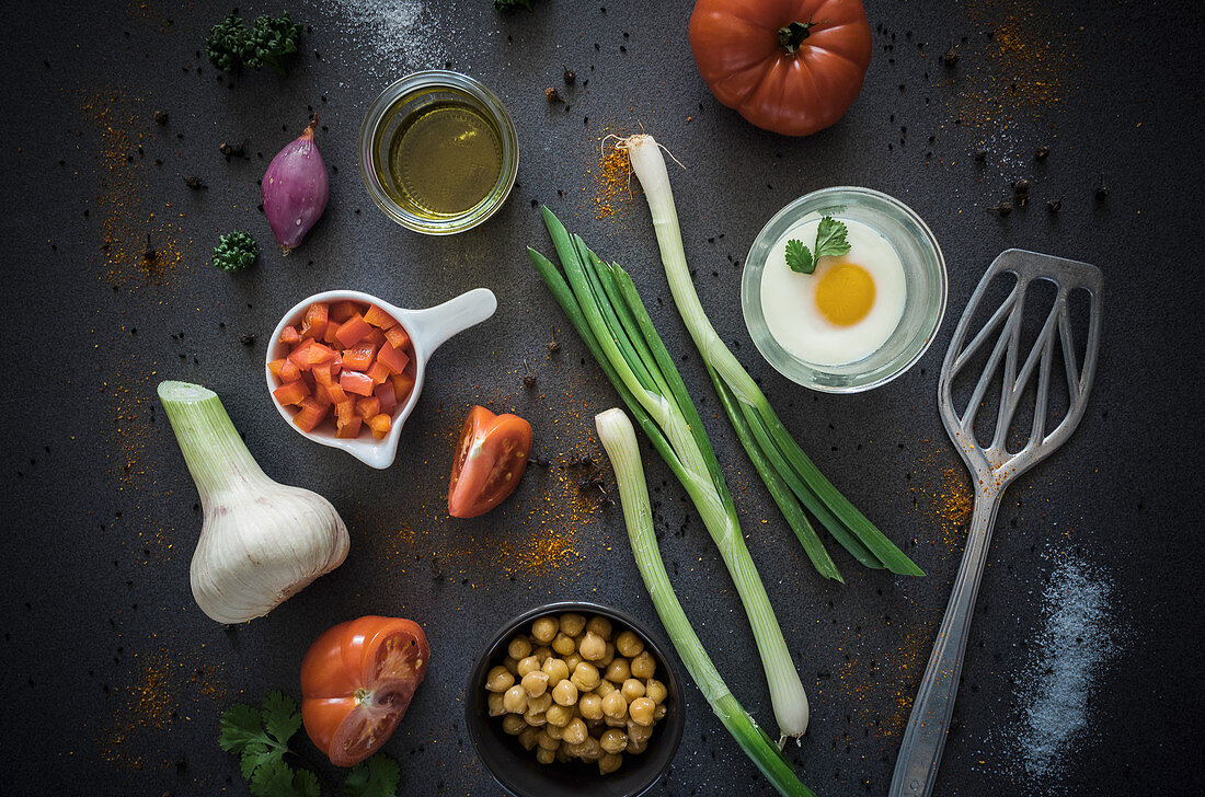 Gemüsezutaten für einen Eintopf mit Kichererbsen, Tomaten, Lauch und Ei