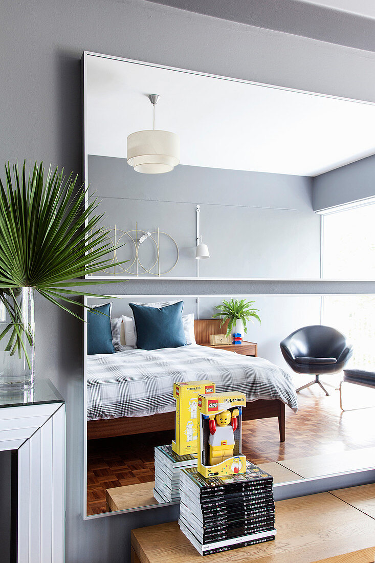 Bedroom reflected in two horizontal mirrors on wall