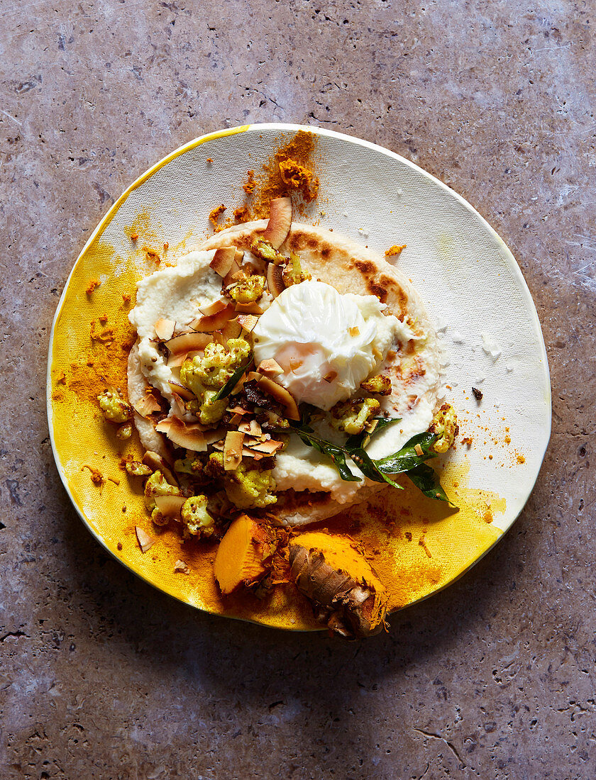 Curry-Blumenkohl und Blumenkohlpüree mit pochiertem Ei auf Fladenbrot
