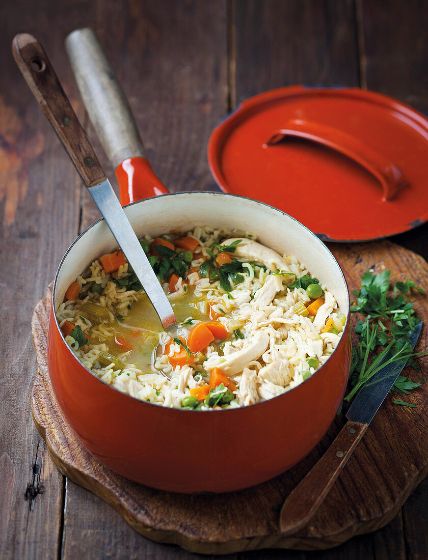 Soup with pasta, chicken, carrots, peas and fresh parsley