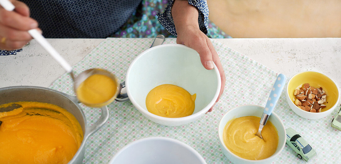 Sweet potato and almond soup being ladled into bowls