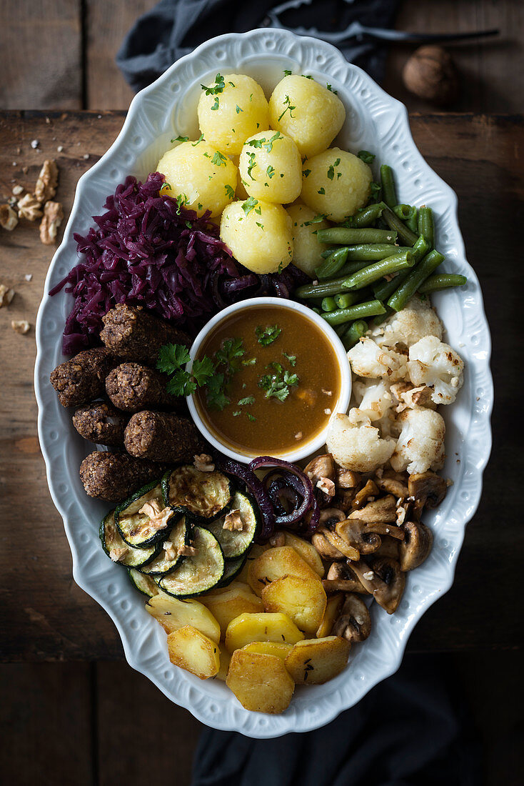 Winterliche vegane Buddha Bowl mit Klössen, Bohnen, Waldpilzsauce, Gemüse und Walnüssen
