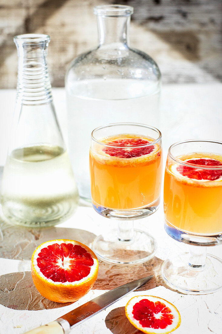 Blutorangen-Spritzer mit Limette auf Tisch im Freien