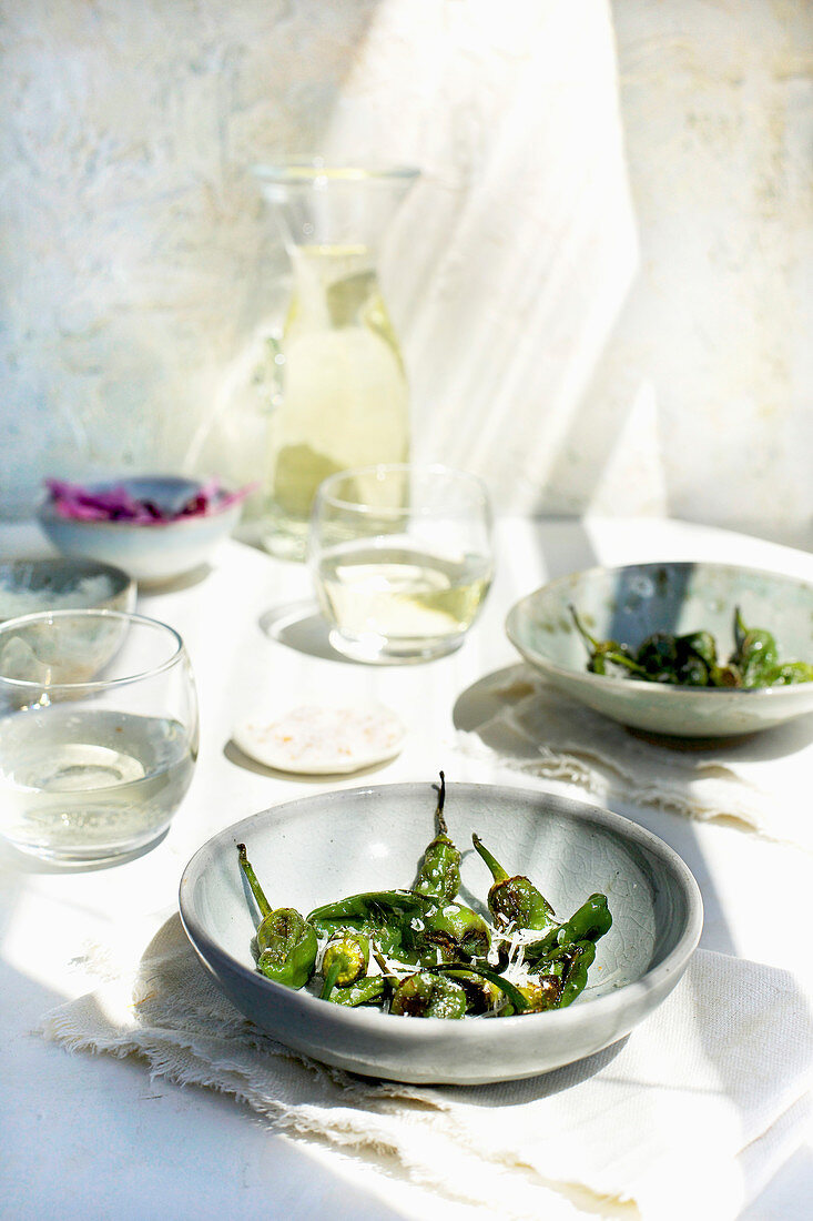 Geröstete Pimientos de Padron serviert mit Maldon-Salz und Weißwein