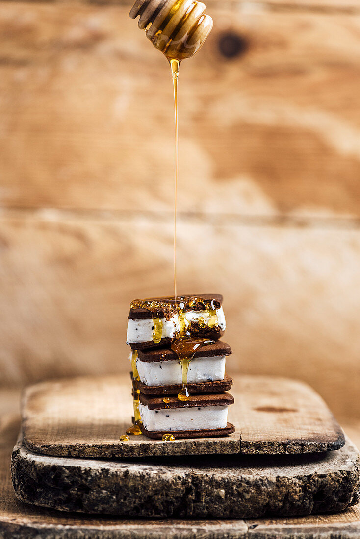 Ice Cream Sandwiches drizzled with honey on a wooden board