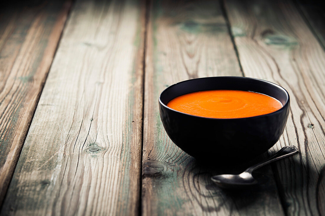 Homemade tomato soup (or gazpacho) over old wooden background