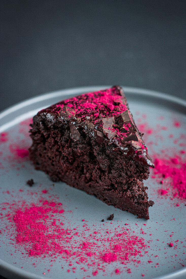 Ein Stück milchfreier Schokoladen-Rote-Bete-Kuchen mit Himbeerpuder