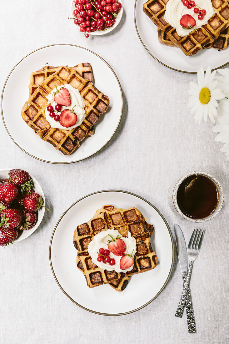 Breakfast waffles topped off with creme fraiche and summer berries