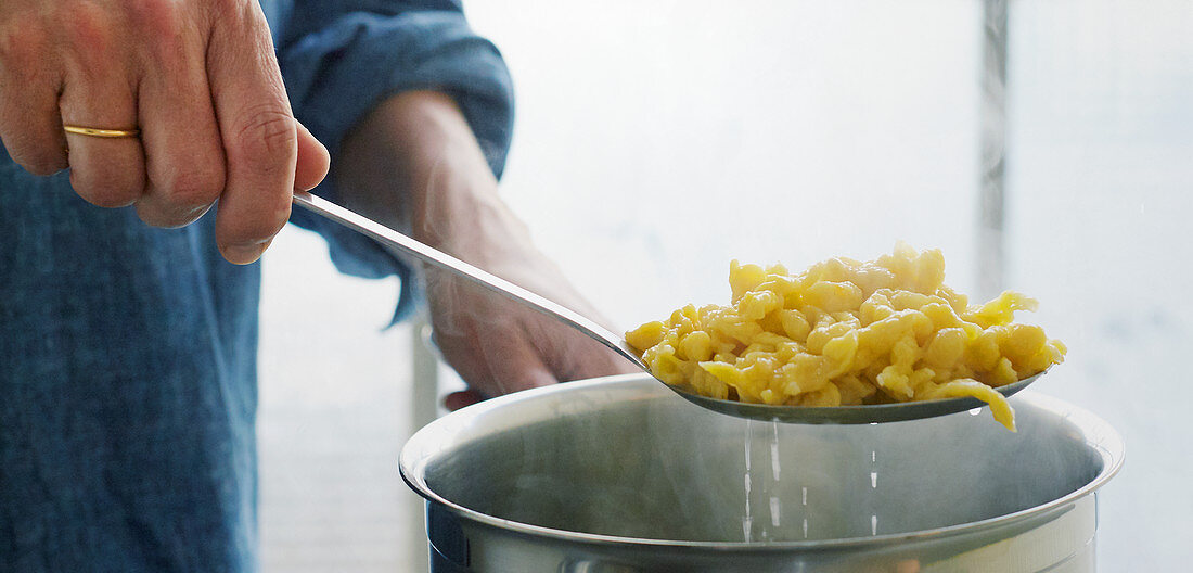 Spätzle being removed from a pot
