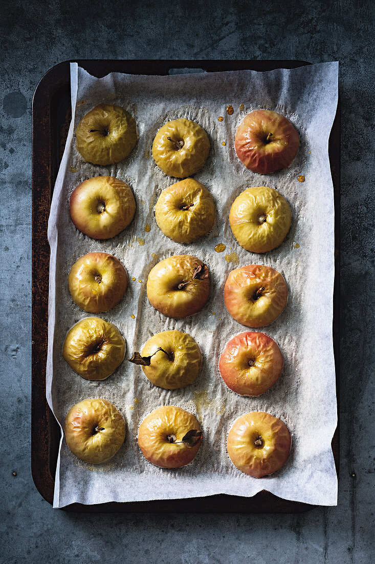 Half baked apples on a baking tray