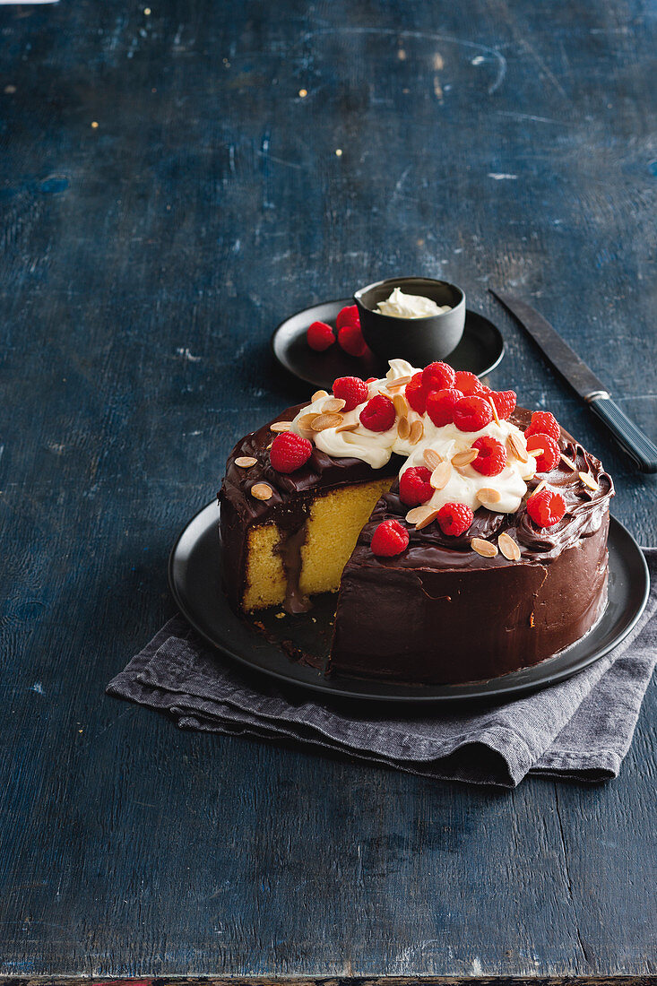 Poke cake with chocolate icing and raspberries