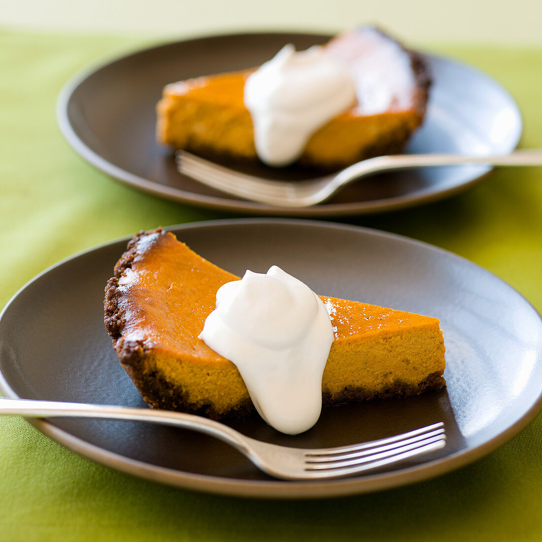 Two slices of pumpkin pie with whipped cream