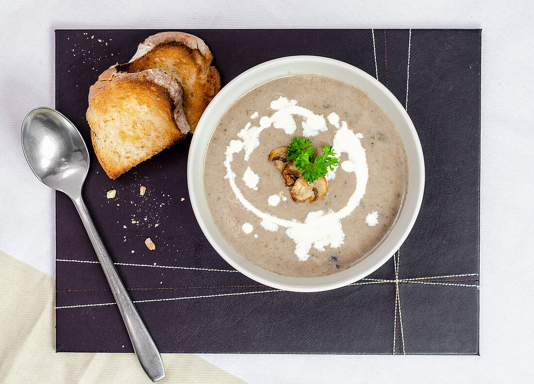 Waldpilzsuppe, garniert mit Petersilie und gerösteten Brotscheiben