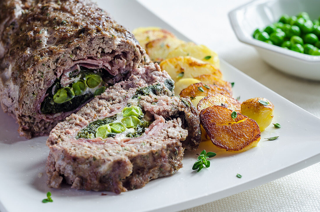 Meatloaf filled with peas and ham with fried potatoes