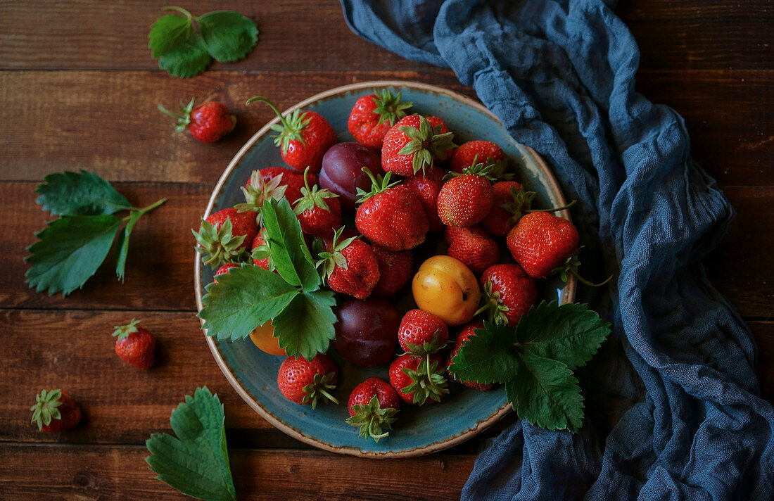 Erdbeeren und Pflaumen auf Teller