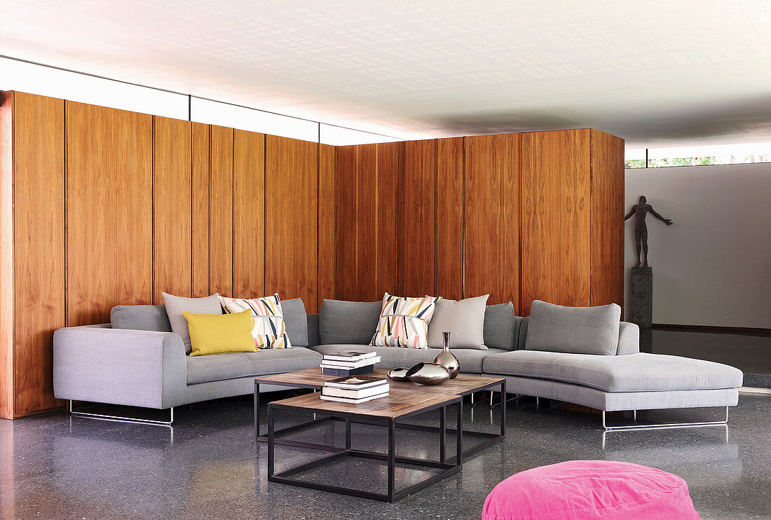 Grey sofa combination against wood panelling in architect-designed house