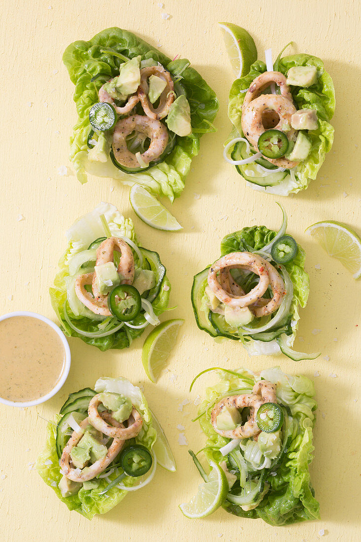 Squid rings with avocado, cucumber and jalapenos on lettuce leaves