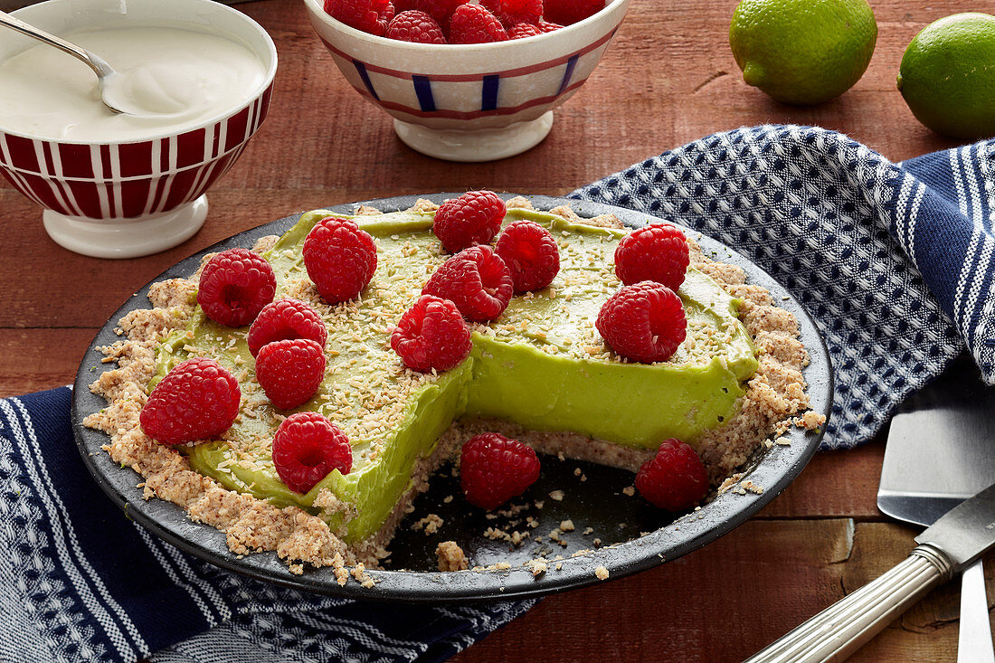 Vegane Avocado-Limetten-Tarte mit Himbeeren, angeschnitten