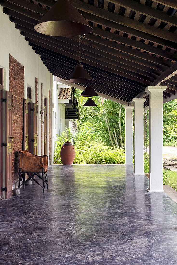 Veranda with leather chair and terracotta urn