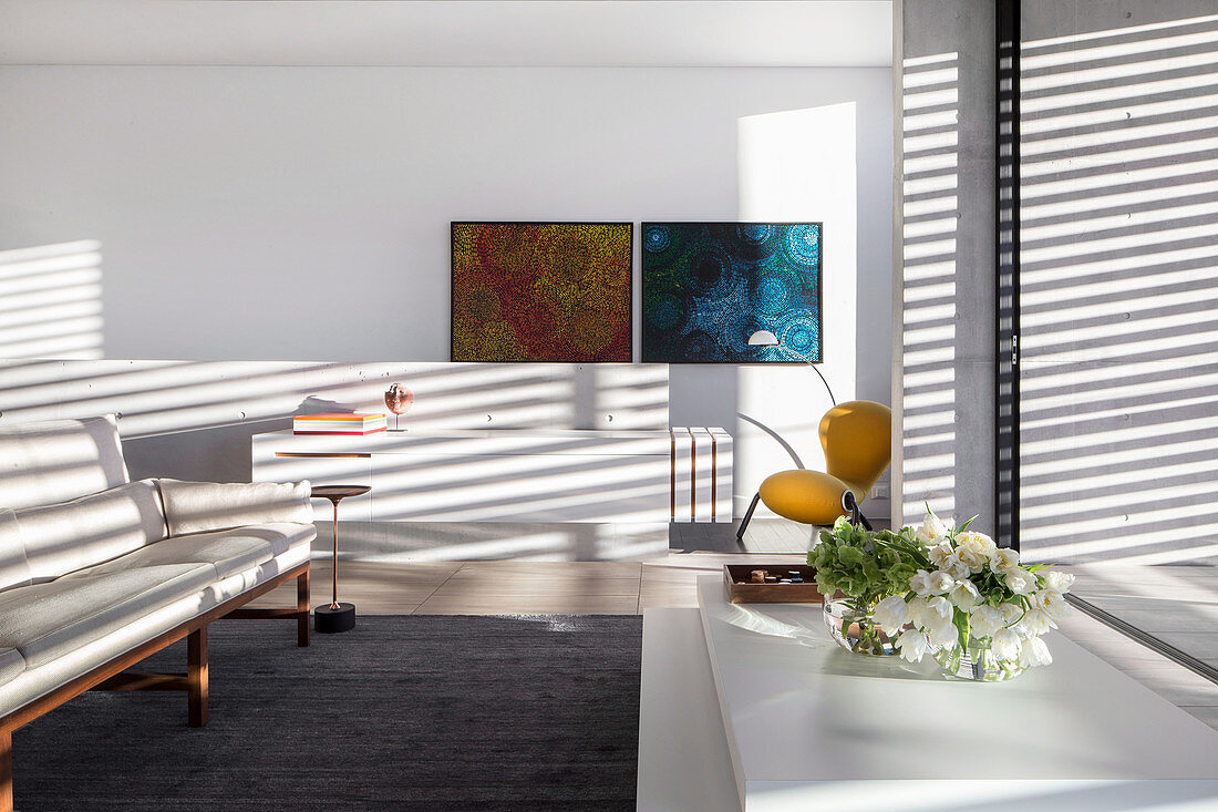 White designer sofa in front of window with aluminum blinds