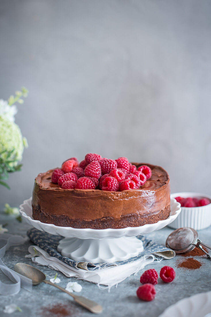 Chocolate cheesecake with fresh raspberries on a cake stand