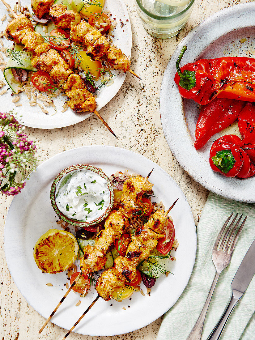 Mediterrane Hähnchenspiesse mit Reis und Salat serviert