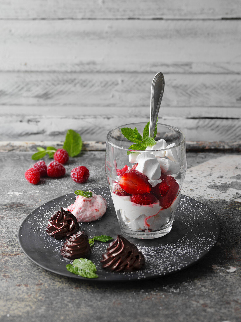 Meringue dessert with vanilla cream, berries and chocolate cream