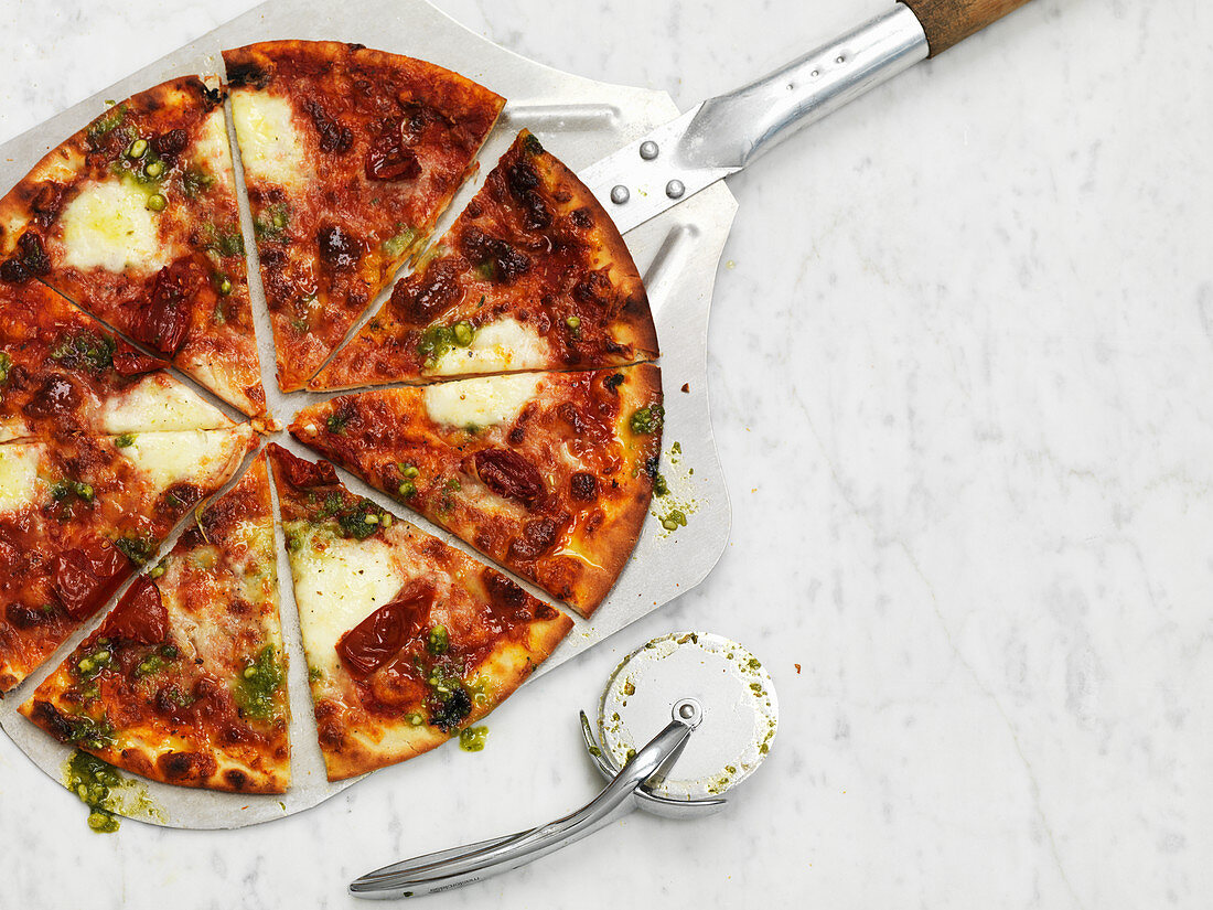 Hot American pizza, sliced, on a pizza paddle