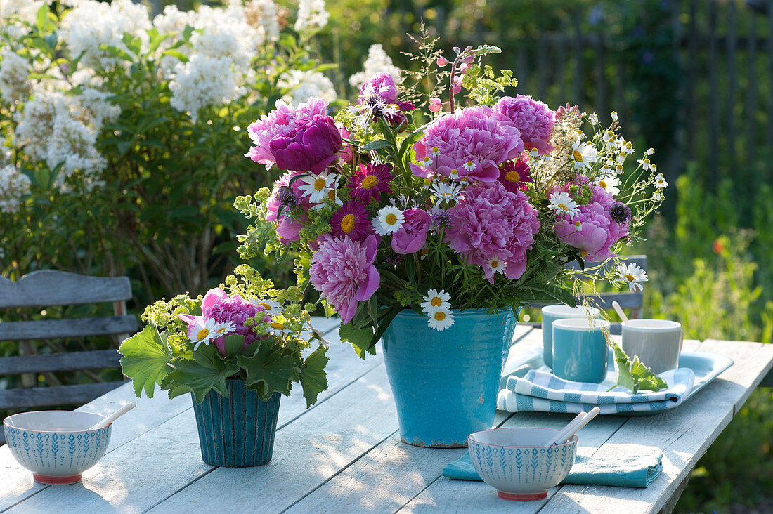 Early summer bouquet in blue vase: Paeonia (peonies), Tanacetum