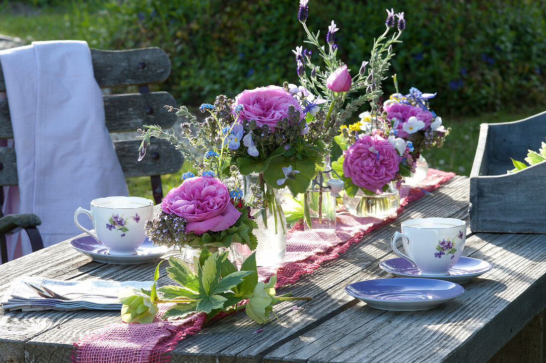 Small bouquets in a row as a table decoration: rosa (roses), thymus