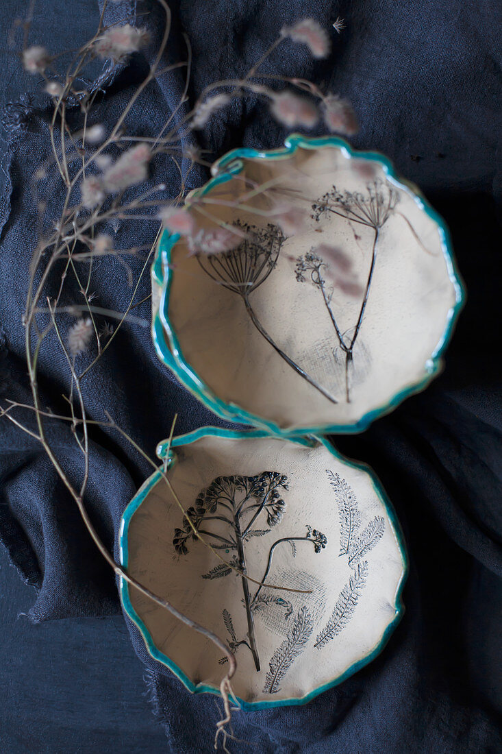 Ceramic bowls with embossed floral motifs and blue rims