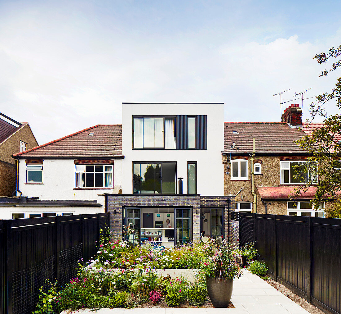 Colourful flowering plants in courtyard garden of terraced house